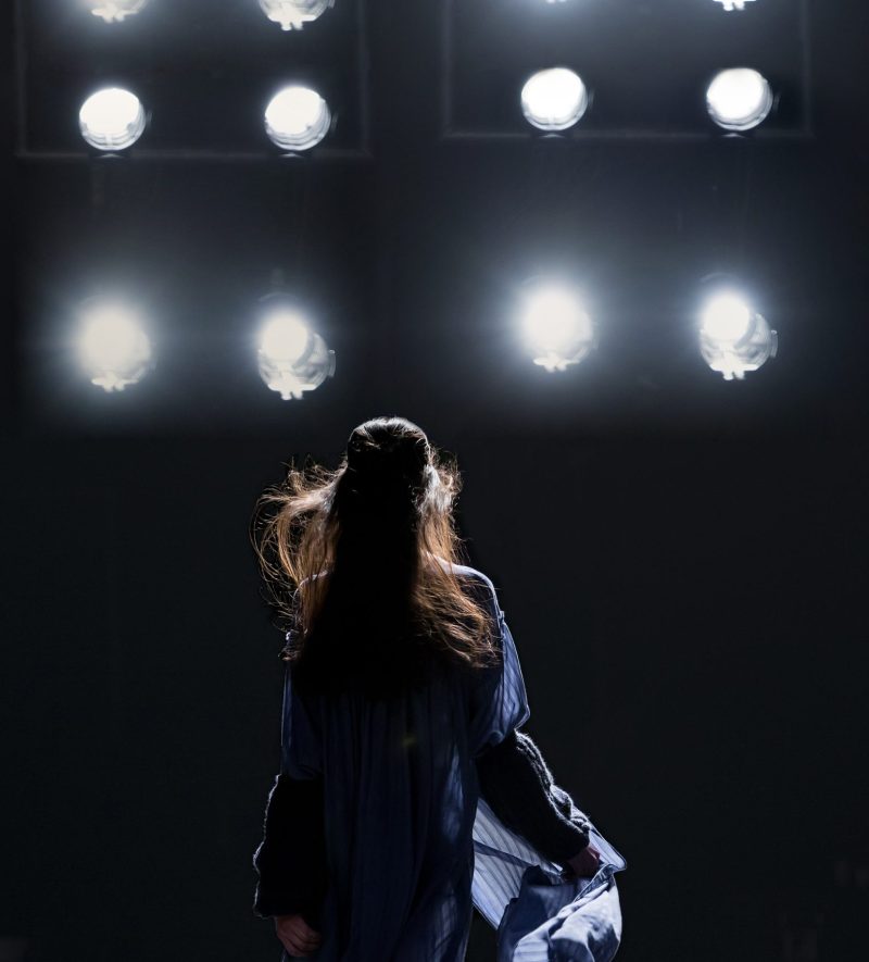 Fashion catwalk runway event, model walking the show finale. Fashion week themed photograph.